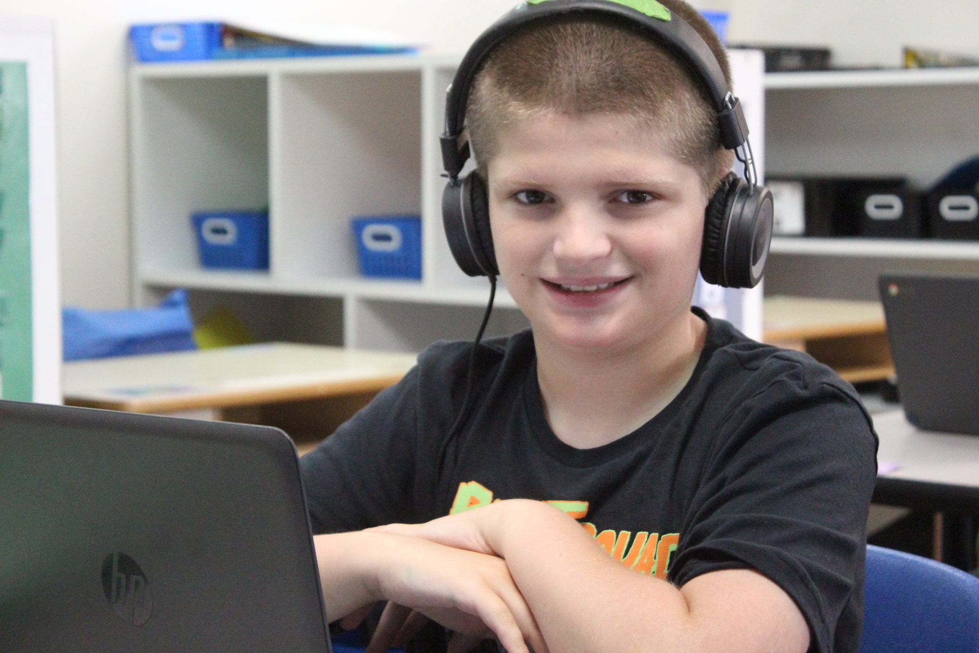 Potential development student with headphones on and laptop out working on assignments